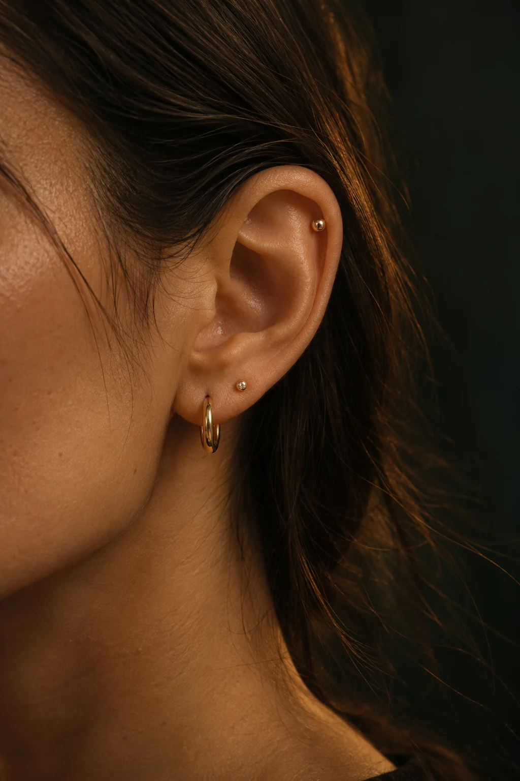 Visuel d’inspiration généré : oreille portant de fins bijoux dorés.