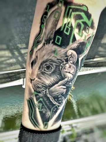 Photographie originale d’un tatouage de lapin avec des éléments graphiques.